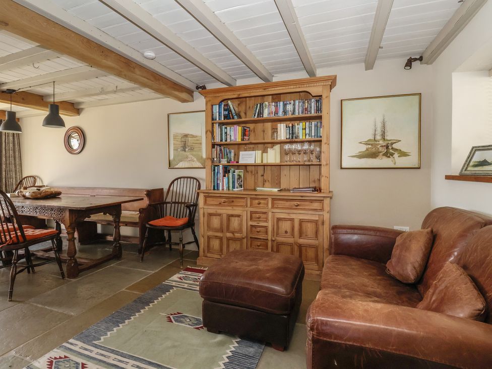 A living room with a bookshelf and dining table at Lyndhurst Carlton-in-Coverdale near Leyburn
