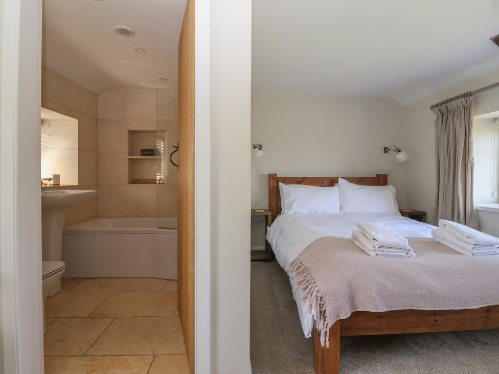 A bathroom with a bathtub and a bedroom with a bed at Lyndhurst, Carlton-in-Coverdale, near Leyburn