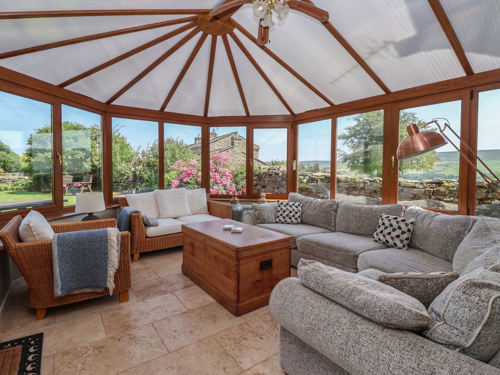 A conservatory with seating and a coffee table at Lyndhurst, Carlton-in-Coverdale, near Leyburn