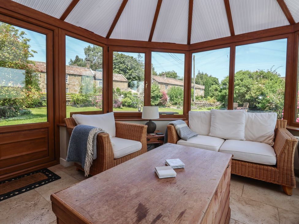 A conservatory with a sofa and coffee table at Lyndhurst in Carlton-in-Coverdale, near Leyburn