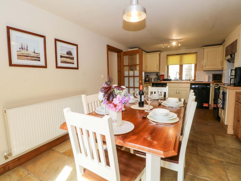 A kitchen with a dining table and chairs at Hurst View Cottage in Biddulph