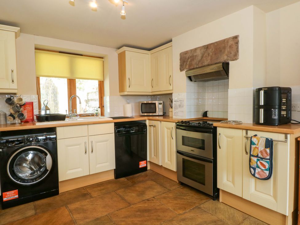 A kitchen with appliances and sink at Hurst View Cottage in Biddulph