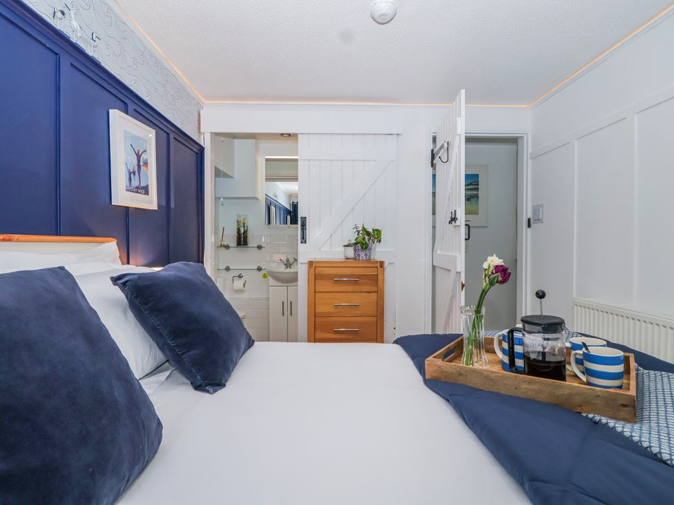 A bedroom with a bed and coffee tray at Lily Cottage in Looe