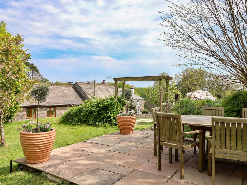 A garden with a table and chairs in a rural setting at Lily Cottage in Looe
