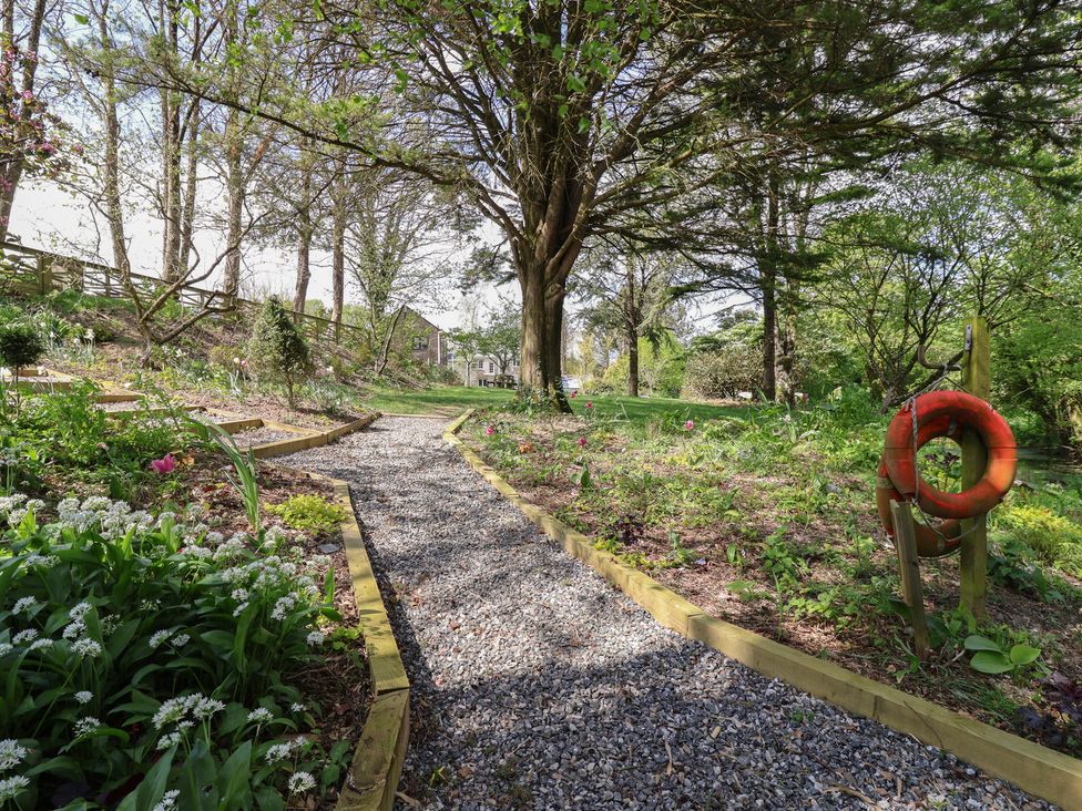 A pathway with gravel and flowers in a garden at Lily Cottage in Looe