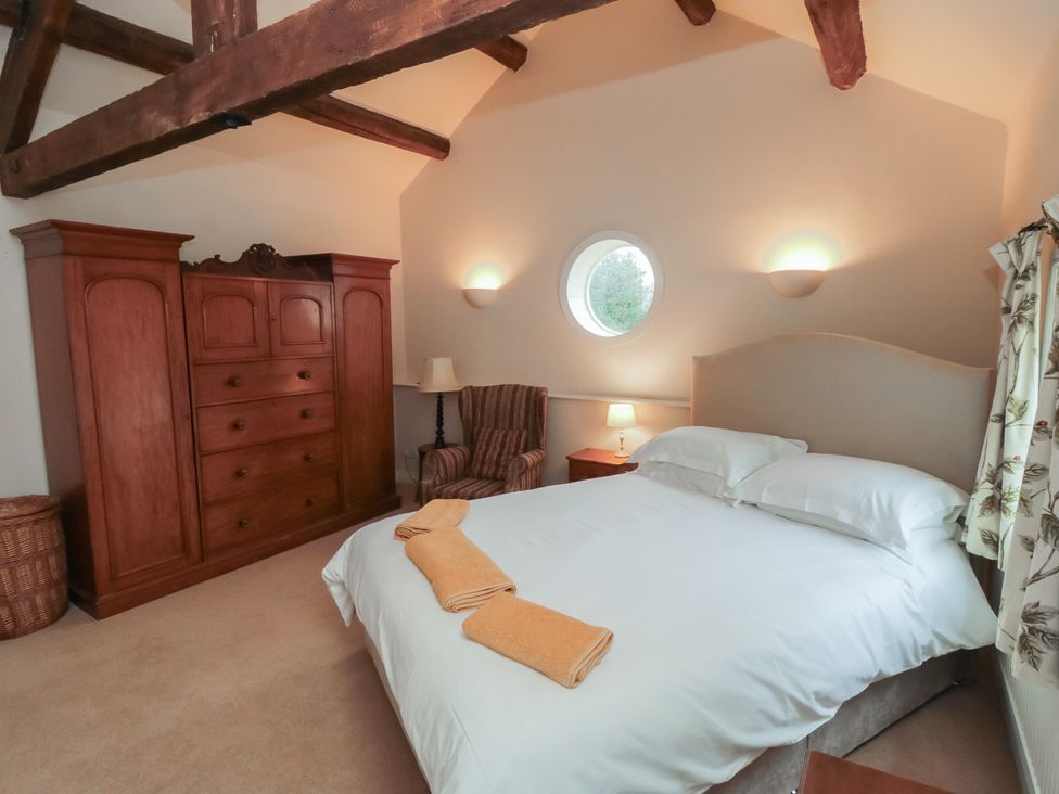 A bedroom with a bed and wardrobe at The Old Milk House