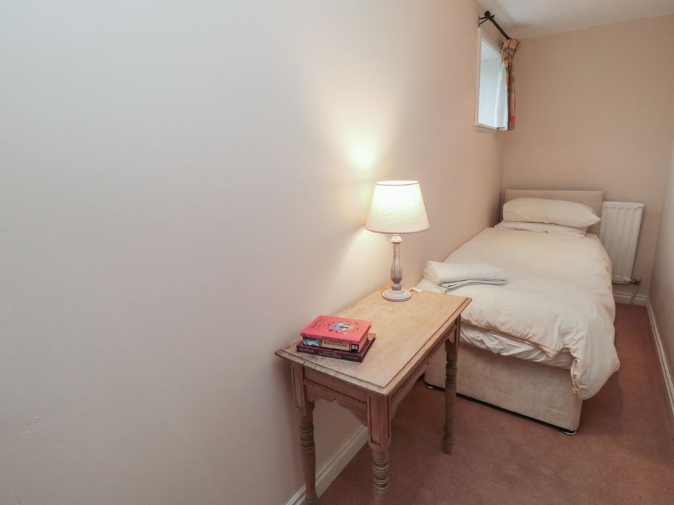 A bedroom with a bed and a lamp on a table at The Old Milk House 