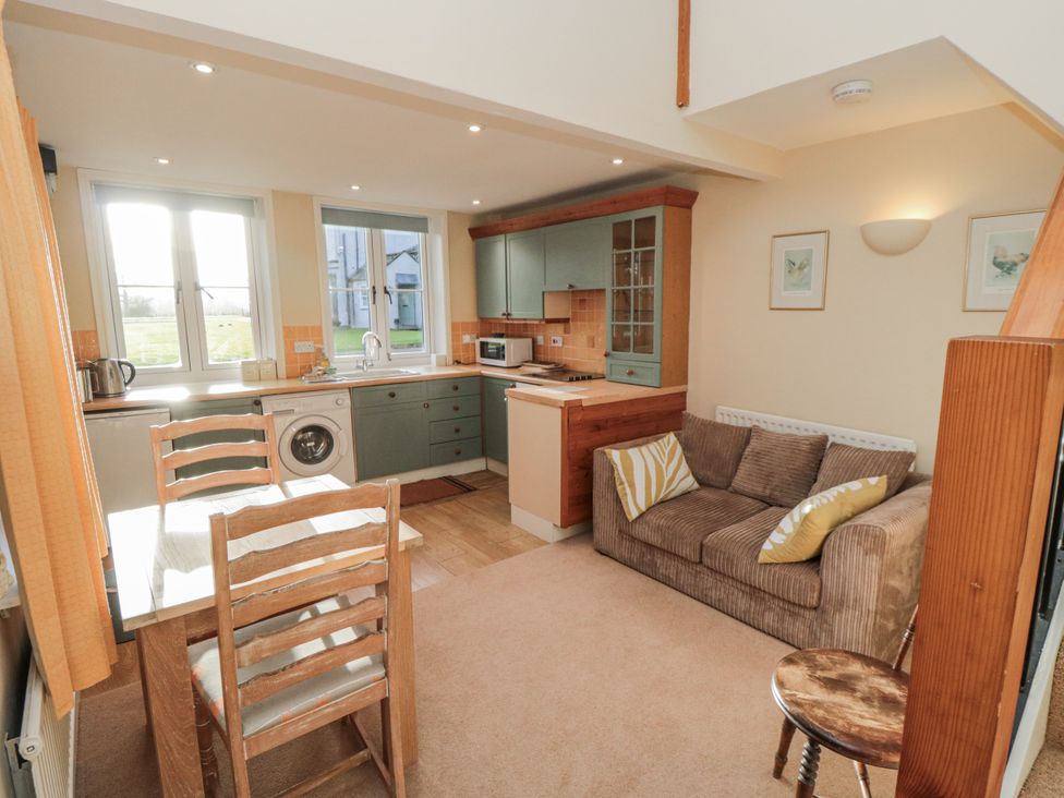 A kitchen with dining table and sofa at The Old Milk House in Potto near Hutton Rudby