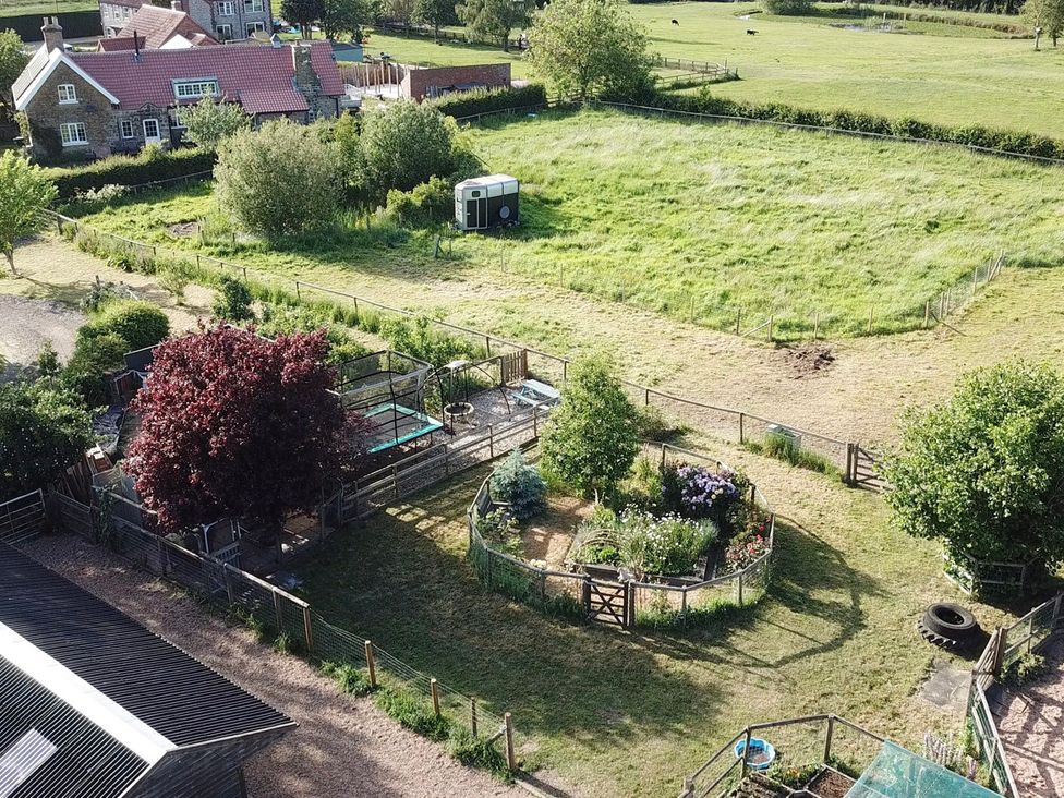 A garden with trees and a house at Gables Cottage in Market Rasen