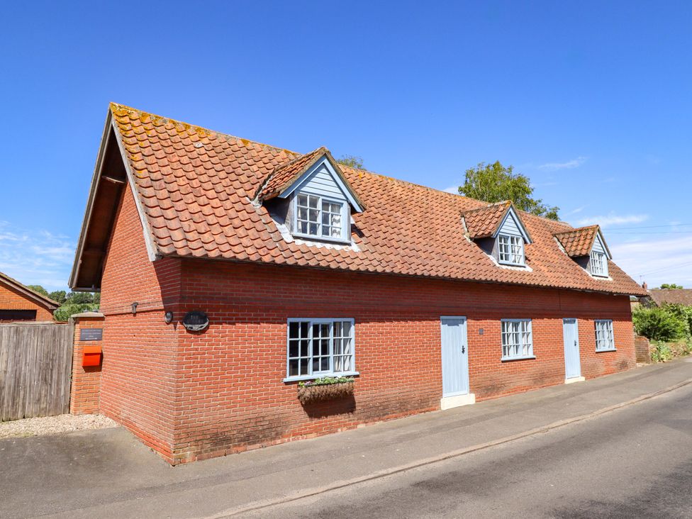 A house with a red brick exterior and blue doors at Gables Cottage in Market Rasen