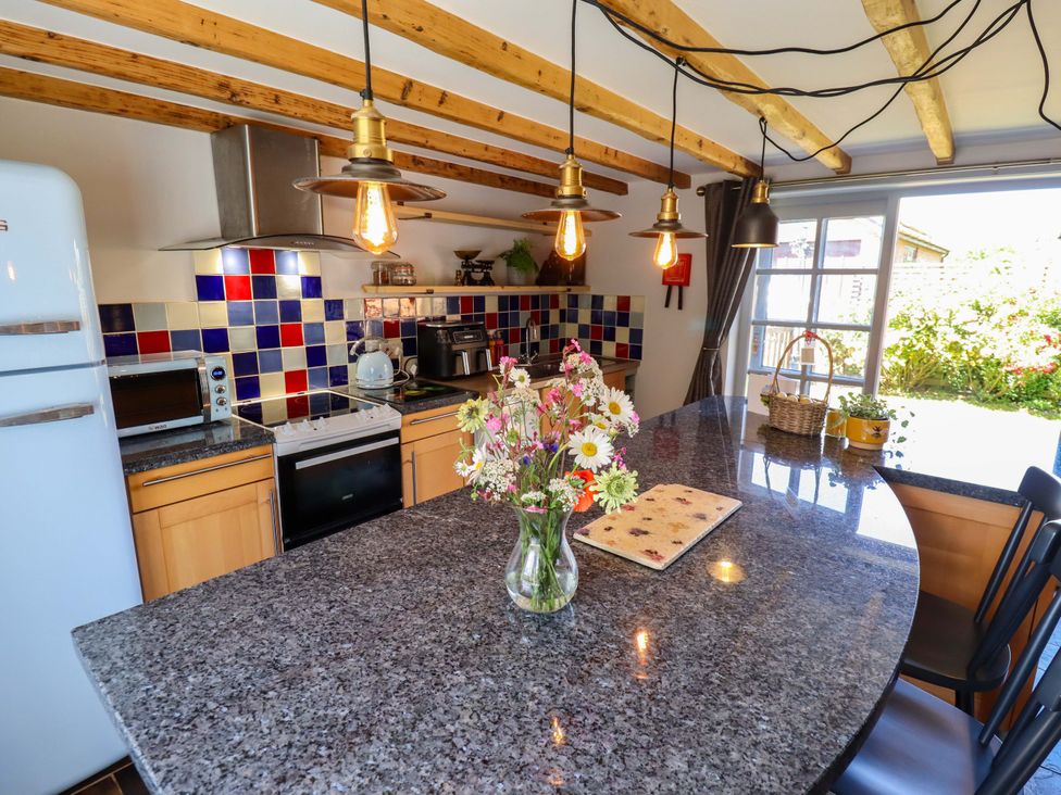 A kitchen with a countertop and flowers at Gables Cottage in Market Rasen