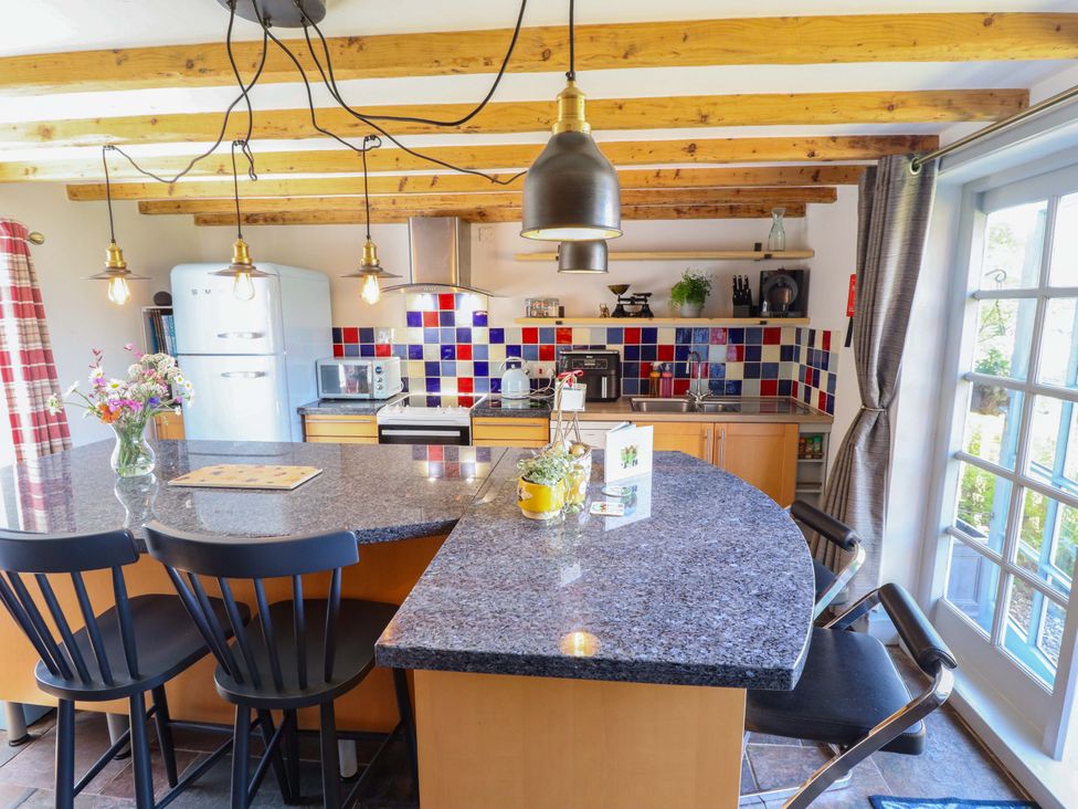 A kitchen with a countertop, appliances and seating at Gables Cottage in Market Rasen