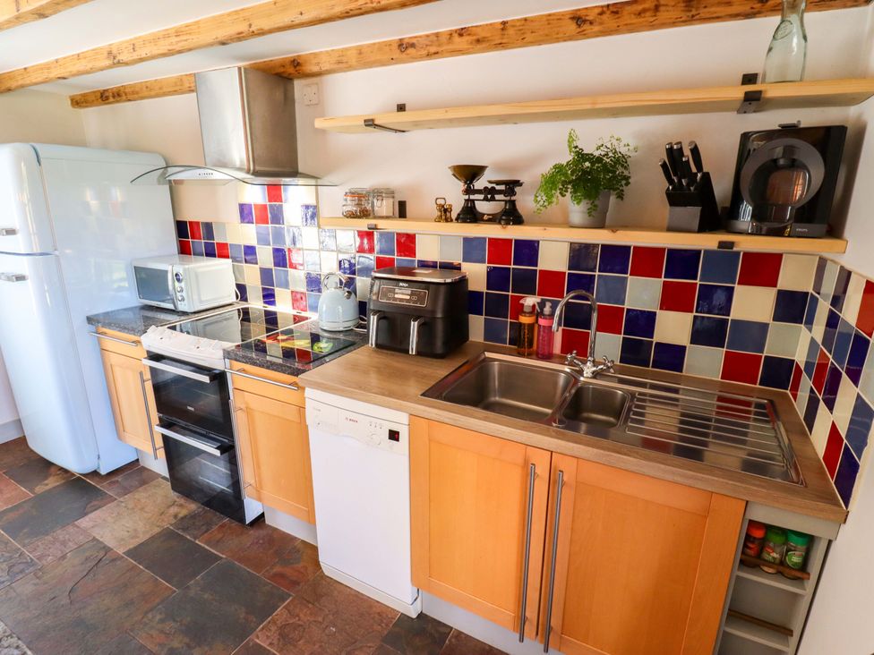 A kitchen with appliances and cabinets at Gables Cottage in Market Rasen