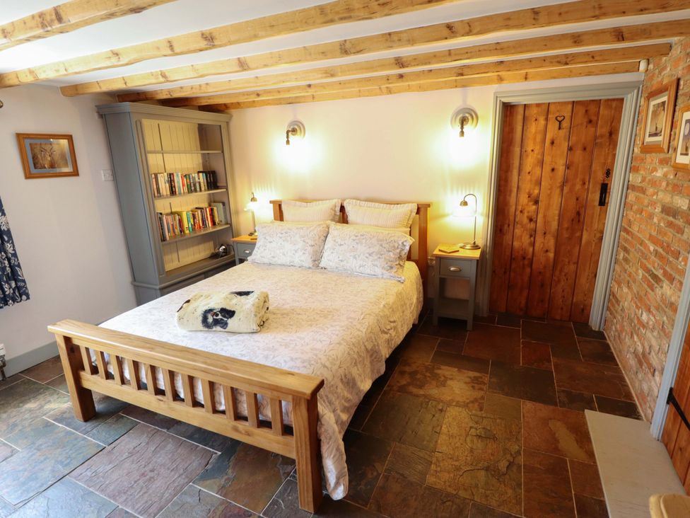 A bedroom with a bed and a bookshelf at Gables Cottage in Market Rasen