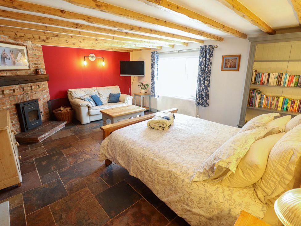 A living room with a sofa and bed at Gables Cottage in Market Rasen
