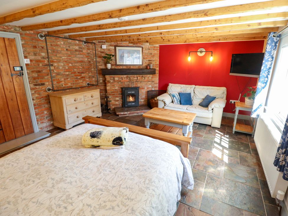 A living room with a bed and sofa at Gables Cottage in Market Rasen