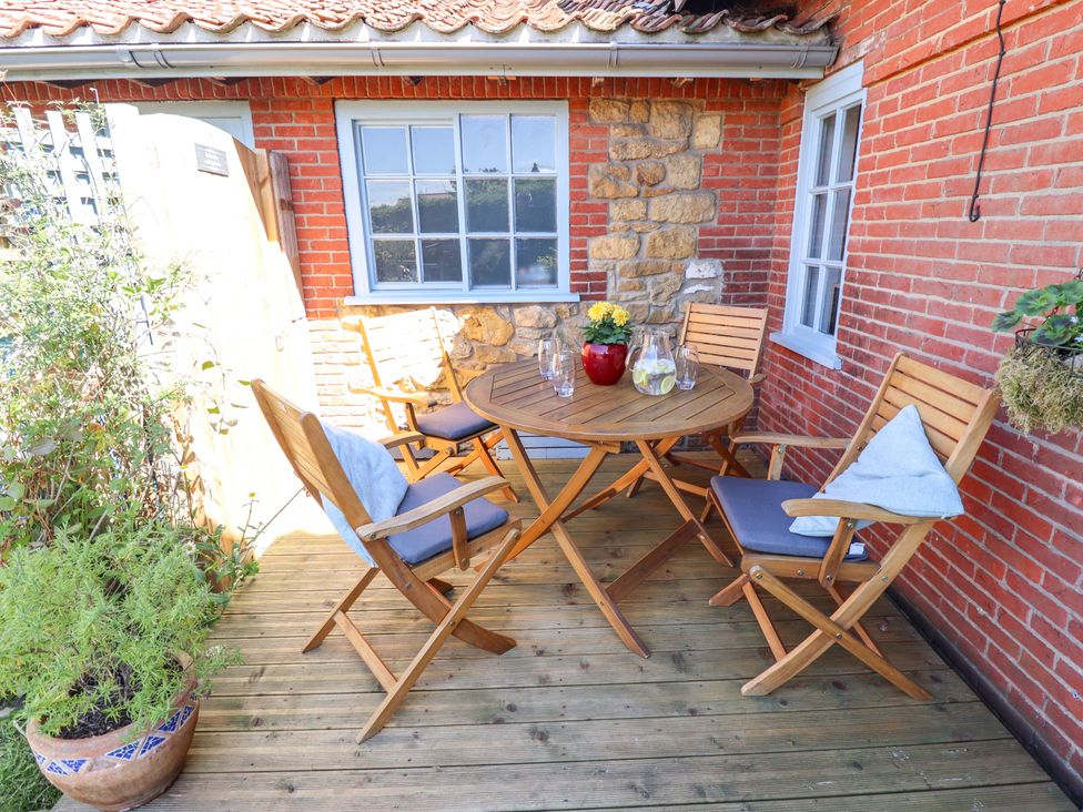 An outdoor patio with a table and chairs at Gables Cottage in Market Rasen