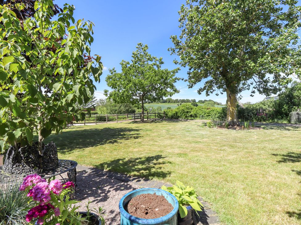 A garden with trees and flowers at Gables Cottage in Market Rasen