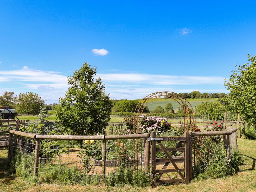 A garden with flowers and a gate at Gables Cottage in Market Rasen