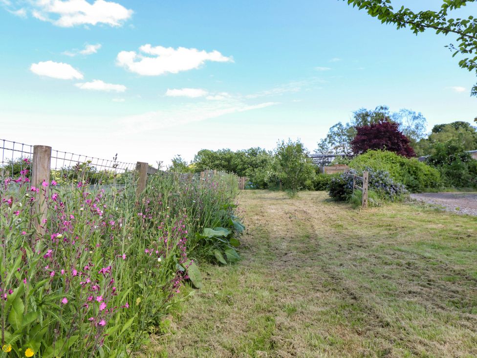 A garden area with flowers and trees at Gables Cottage in Market Rasen