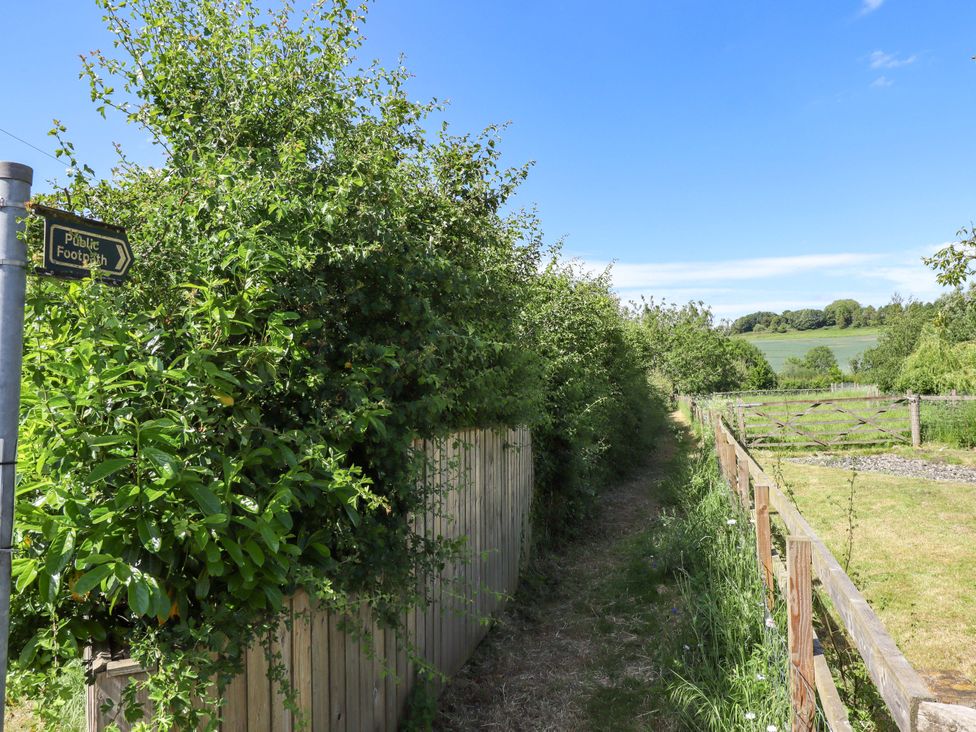 A public footpath bordered by bushes and a fence at Gables Cottage in Market Rasen