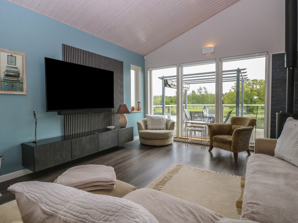 A living room with a tv and sofa at Links View in Fritton