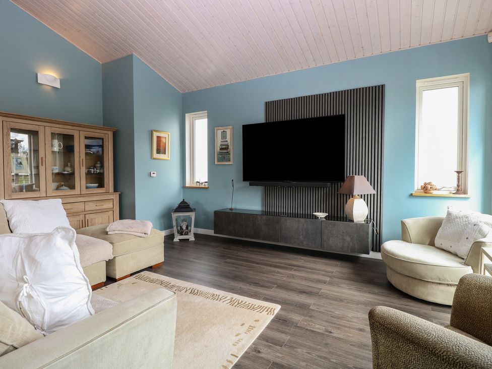 A living room with a sofa and television at Links View in Fritton