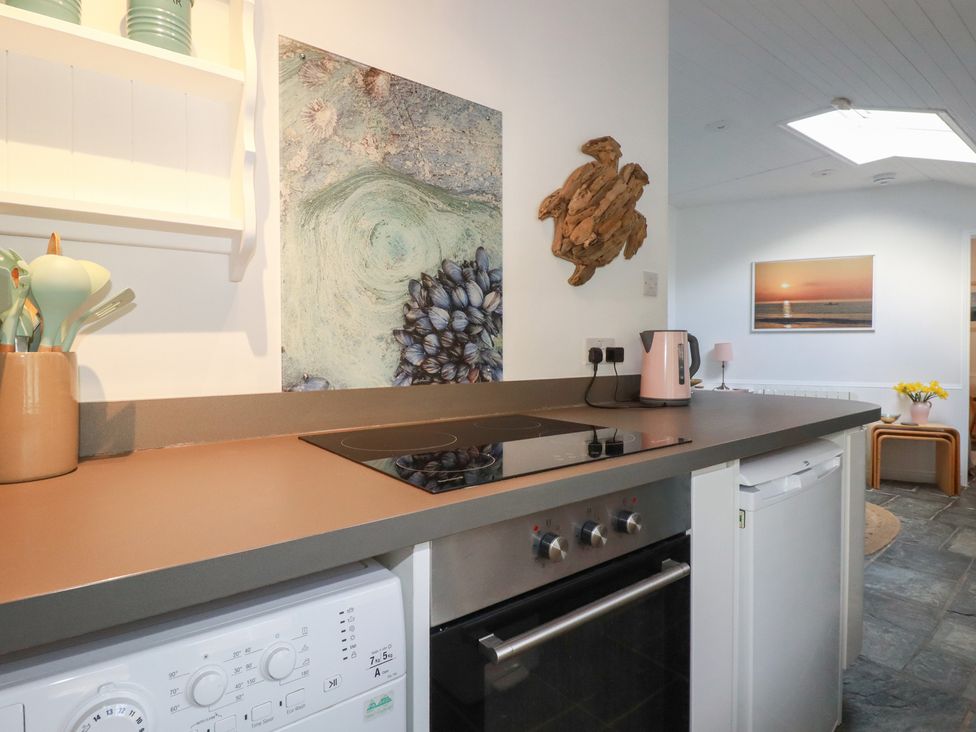 A kitchen with a countertop and appliances at Smugglers Cottage Trebarwith Strand near Tintagel