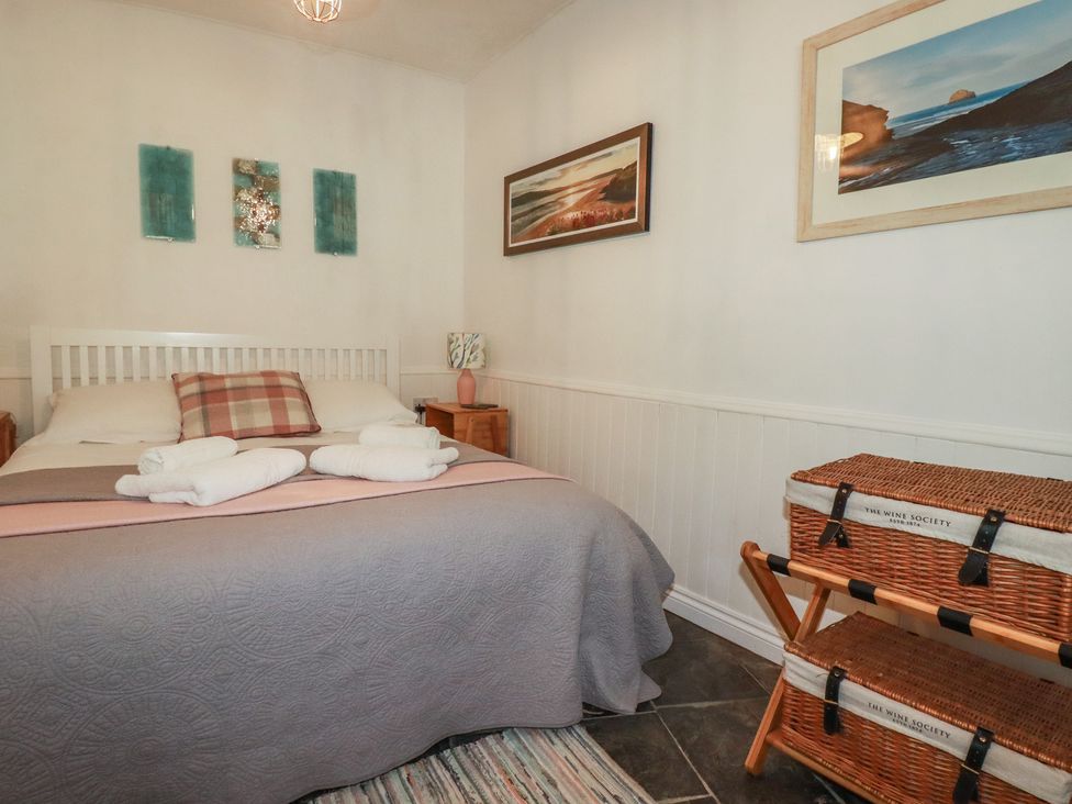 A bedroom with a bed and nightstand at Smugglers Cottage Trebarwith Strand near Tintagel
