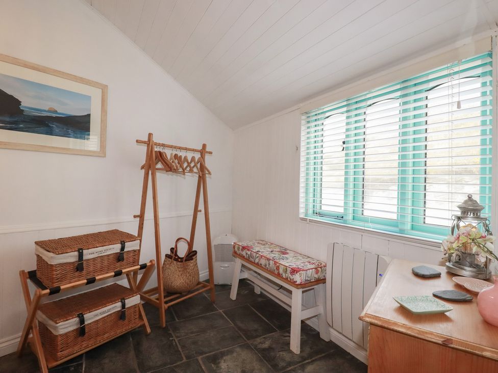 A room with storage baskets and a hanging rack at Smugglers Cottage in Trebarwith Strand near Tintagel