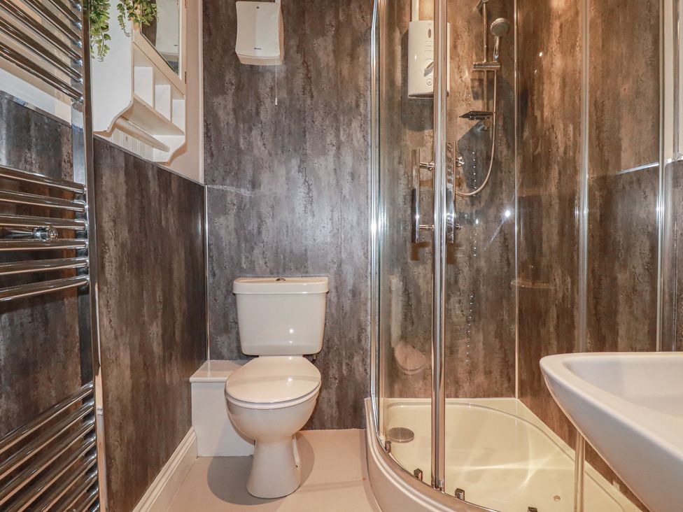 A bathroom with a shower and toilet at Smugglers Cottage Trebarwith Strand near Tintagel