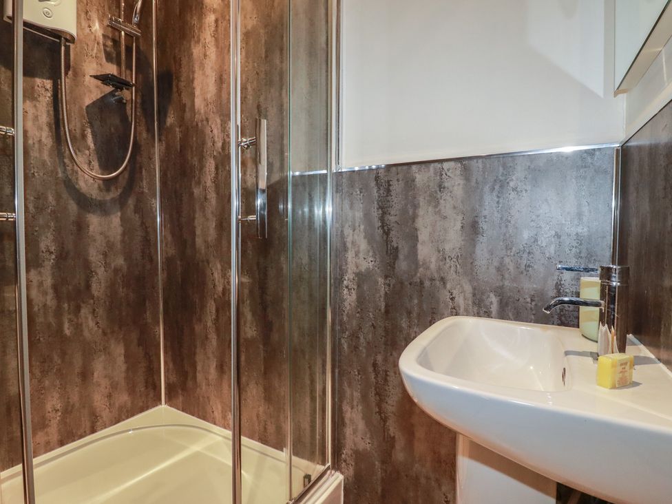 A bathroom with a shower and sink at Smugglers Cottage near Tintagel