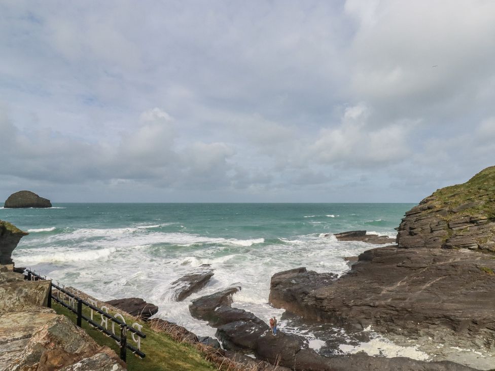 An ocean view with waves and rock formations at Smugglers Cottage in Trebarwith Strand near Tintagel