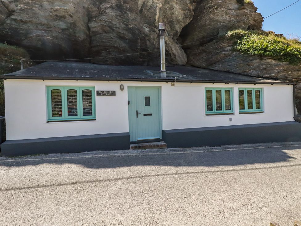 A cottage with a blue door and windows at Smugglers Cottage Trebarwith Strand near Tintagel