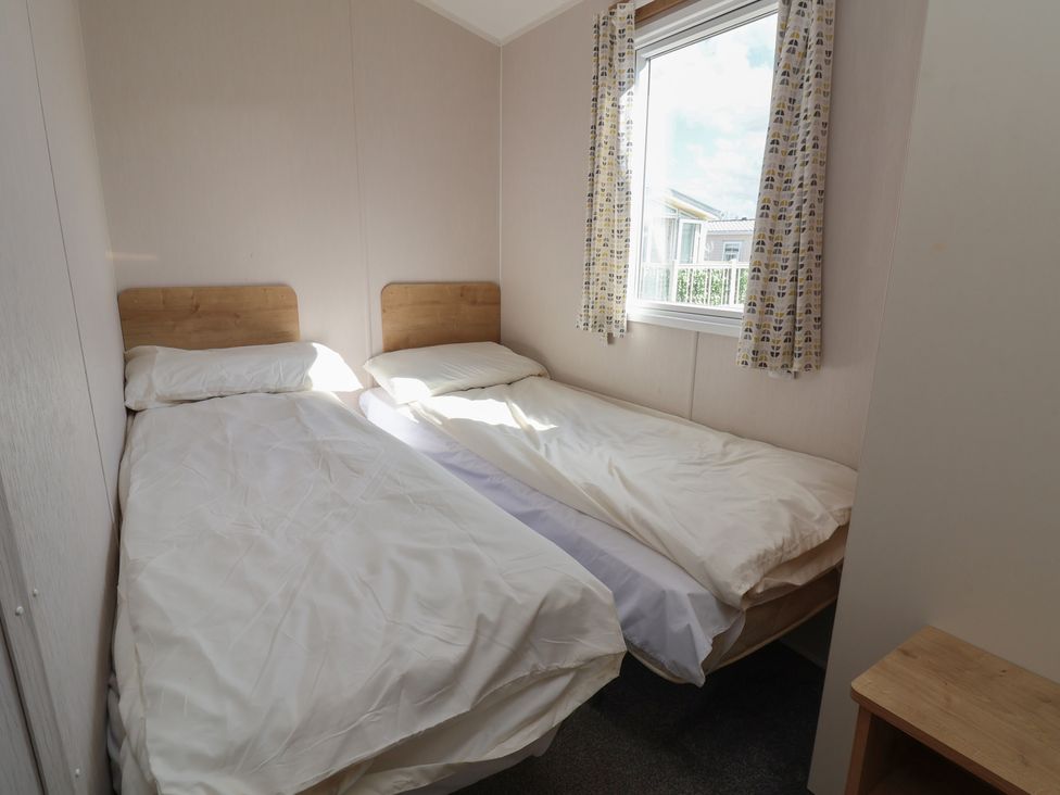 A bedroom with two single beds and a window at K2 Static Caravan
