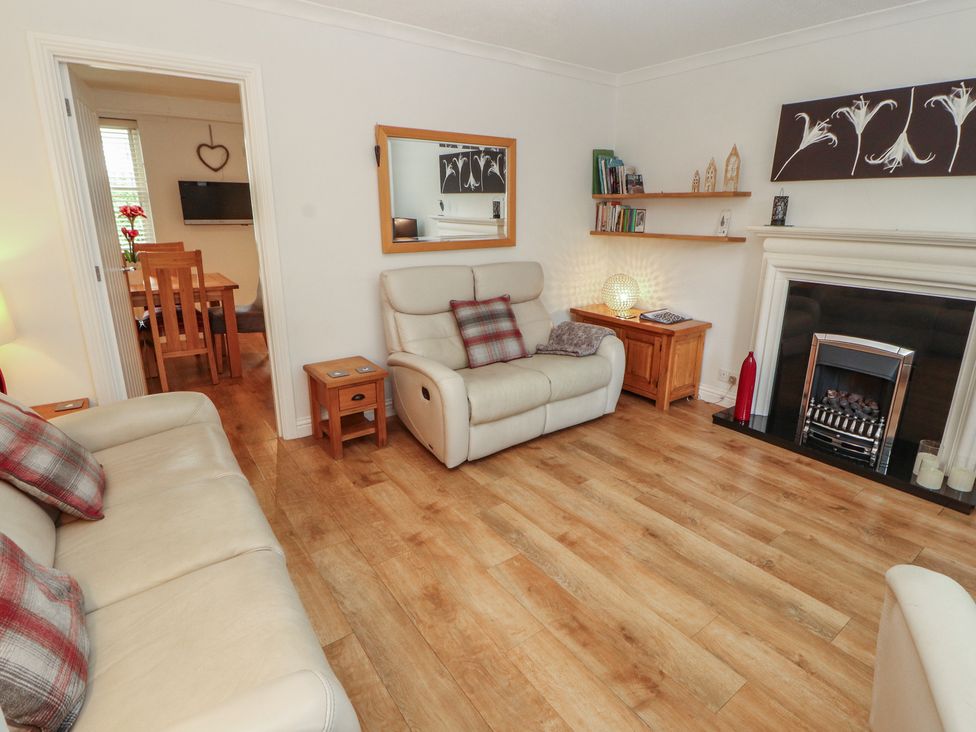 A living room with seating and fireplace at Riverside Cottage Cockermouth