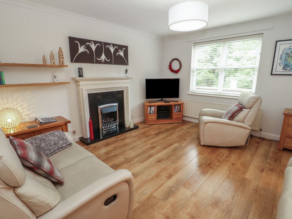 A living room with furniture and a television at Riverside Cottage in Cockermouth