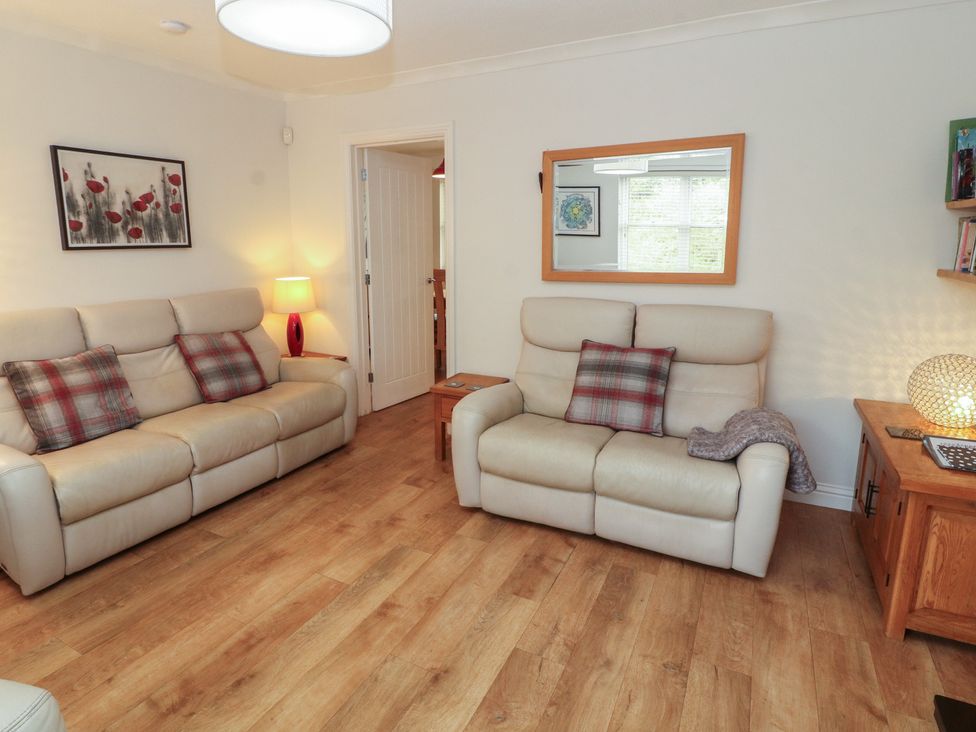 A living room with two sofas and a lamp at Riverside Cottage in Cockermouth