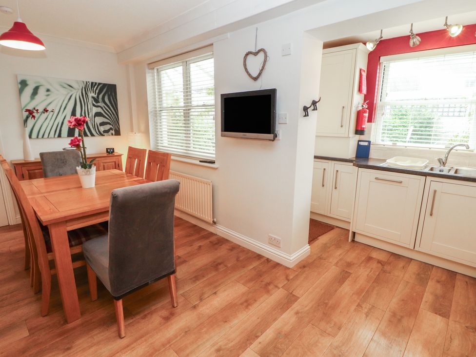 A dining room with a table and chairs at Riverside Cottage in Cockermouth