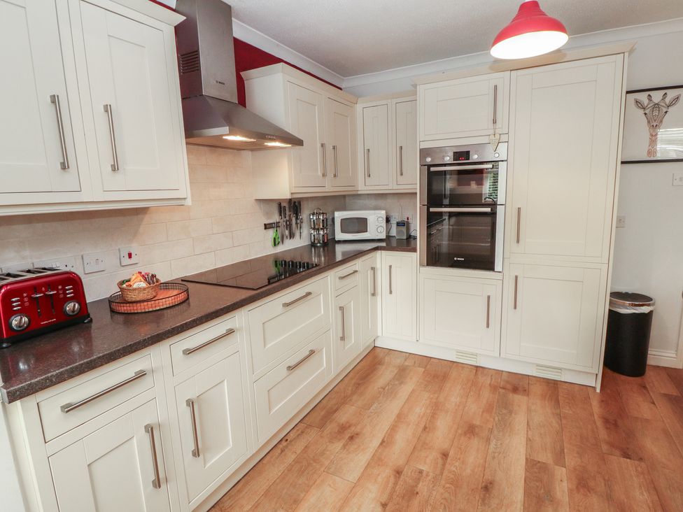 A kitchen with cabinets and appliances at Riverside Cottage in Cockermouth