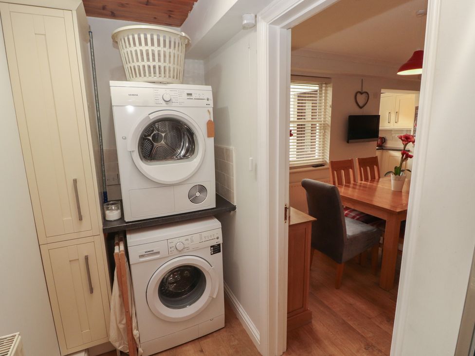 A laundry room with appliances and a dining area at Riverside Cottage in Cockermouth