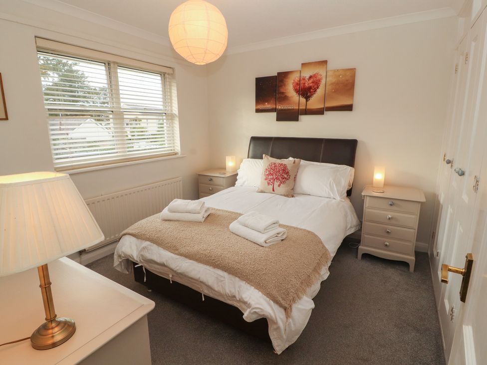A bedroom with a bed and a nightstand at Riverside Cottage Cockermouth