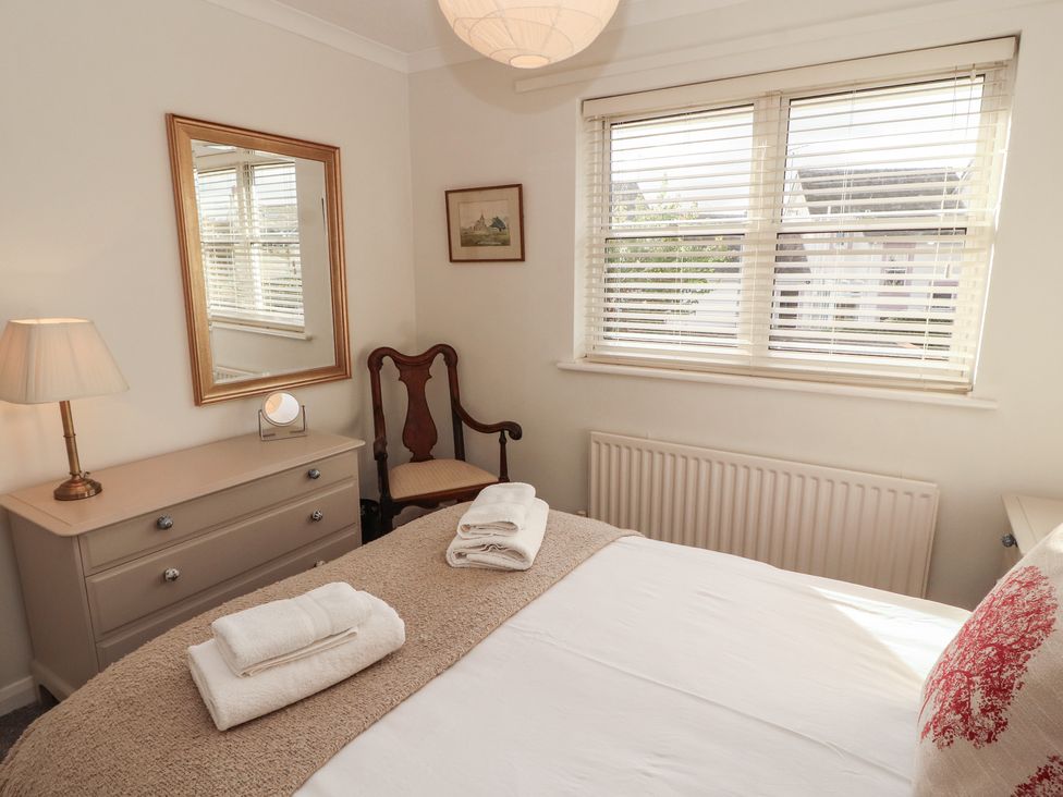 A bedroom with a bed and dresser at Riverside Cottage Cockermouth