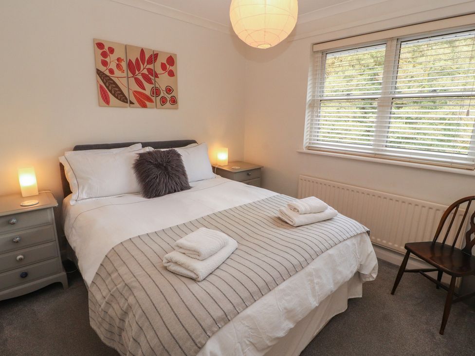 A bedroom with a bed and nightstands at Riverside Cottage in Cockermouth