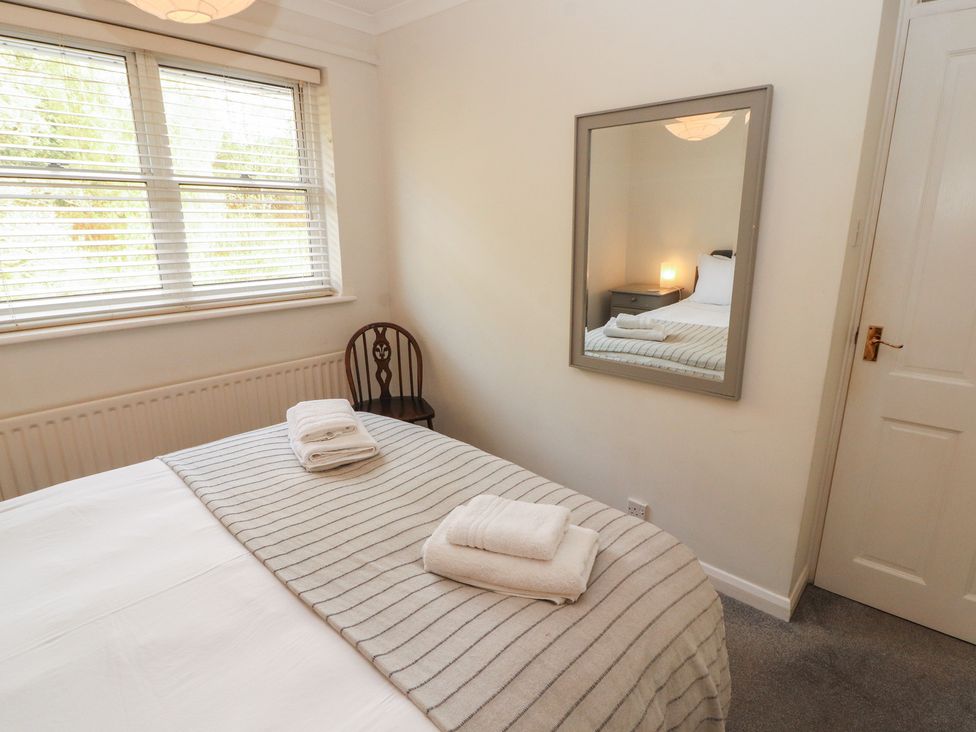 A bedroom with a bed and mirror at Riverside Cottage Cockermouth
