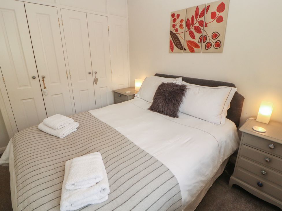 A bedroom with a bed and bedside tables at Riverside Cottage in Cockermouth