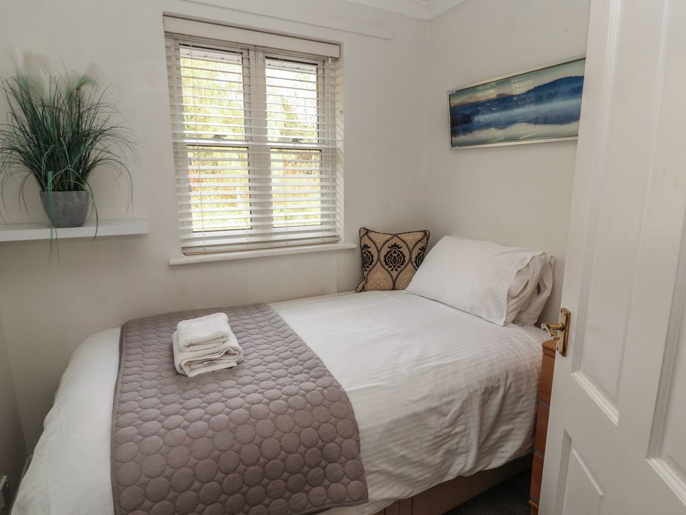 A bedroom with a bed and decorative items at Riverside Cottage in Cockermouth