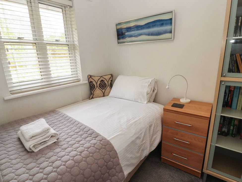 A bedroom with a bed and nightstand at Riverside Cottage Cockermouth