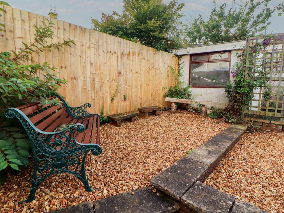 A garden with a bench and gravel at Riverside Cottage in Cockermouth