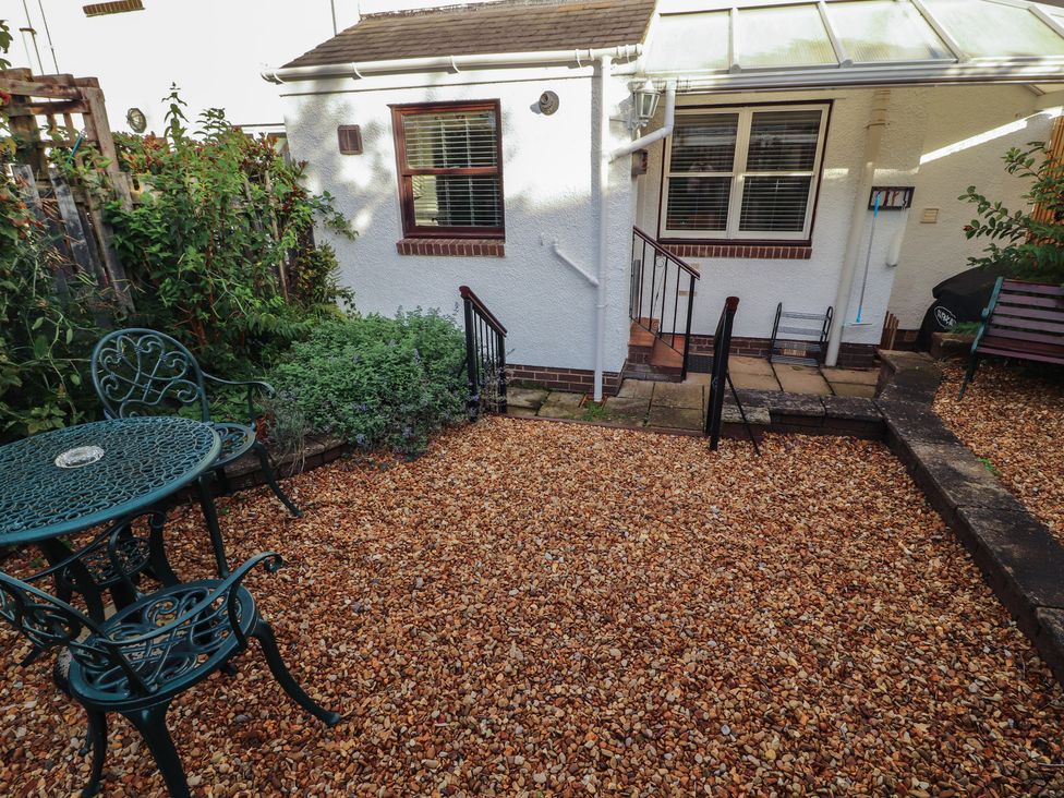 A garden with a table and chairs at Riverside Cottage in Cockermouth